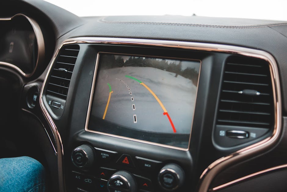 Close-up of a car's dashboard showing a rearview camera display for parking assistance.